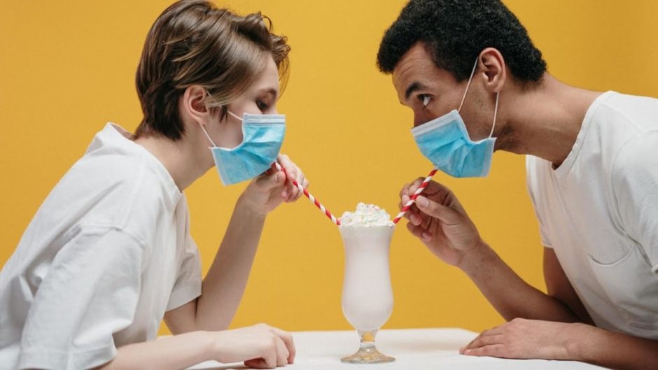 Paradox of two people wearing masks and drinking a milkshake.