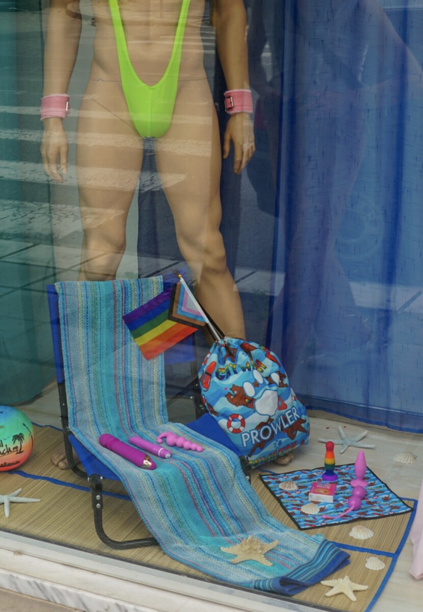 Pride month window display with mannequin, pride flag and sex toys.